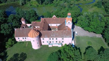 Letonya 'daki Edole Kalesi, Courland (Kurzeme), Batı Letonya. Tarih, Mimarlık, Seyahat Destinasyonları, Ulusal Kent Simgesi. Edole Ortaçağ Şatosu 'nun Güneşli Yaz Gününde Neogotik Biçimli Hava Görüntüsü