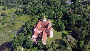 Letonya 'daki Edole Kalesi, Courland (Kurzeme), Batı Letonya. Tarih, Mimarlık, Seyahat Destinasyonları, Ulusal Kent Simgesi. Edole Ortaçağ Şatosu 'nun Güneşli Yaz Gününde Neogotik Biçimli Hava Görüntüsü