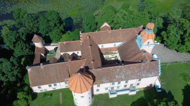 Letonya 'daki Edole Kalesi, Courland (Kurzeme), Batı Letonya. Tarih, Mimarlık, Seyahat Destinasyonları, Ulusal Kent Simgesi. Edole Ortaçağ Şatosu 'nun Güneşli Yaz Gününde Neogotik Biçimli Hava Görüntüsü