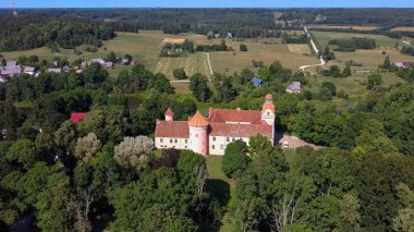 Letonya 'daki Edole Kalesi, Courland (Kurzeme), Batı Letonya. Tarih, Mimarlık, Seyahat Destinasyonları, Ulusal Kent Simgesi. Edole Ortaçağ Şatosu 'nun Güneşli Yaz Gününde Neogotik Biçimli Hava Görüntüsü