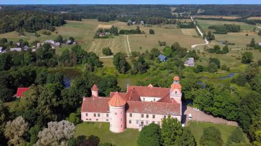 Letonya 'daki Edole Kalesi, Courland (Kurzeme), Batı Letonya. Tarih, Mimarlık, Seyahat Destinasyonları, Ulusal Kent Simgesi. Edole Ortaçağ Şatosu 'nun Güneşli Yaz Gününde Neogotik Biçimli Hava Görüntüsü