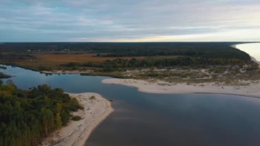 Gauja Nehri, Riga 'nın Baltık Denizi Körfezi' ne akıyor. Fırtına Sonrası Kırık Çamlar ve Yıkanmış Kıyılar. Hava Aracı Üst Görünüm Sonbahar Akşamı Gündoğumu Nehir Kanalizasyonu 'nda Denize