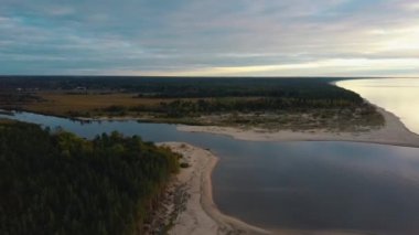 Gauja Nehri, Riga 'nın Baltık Denizi Körfezi' ne akıyor. Fırtına Sonrası Kırık Çamlar ve Yıkanmış Kıyılar. Hava Aracı Üst Görünüm Sonbahar Akşamı Gündoğumu Nehir Kanalizasyonu 'nda Denize
