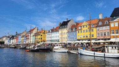 07 Ağustos 2024, Kopenhag şehir merkezi, Danimarka Yaz Günü manzaralı kanalı botlar ve turistler, renkli binalar ve rıhtım boyunca bisikletçiler, Avrupa başkentindeki canlı kentsel atmosfer