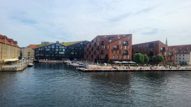 07 Ağustos 2024, Kopenhag şehir merkezi, Danimarka Yaz Günü manzaralı kanalı botlar ve turistler, renkli binalar ve rıhtım boyunca bisikletçiler, Avrupa başkentindeki canlı kentsel atmosfer