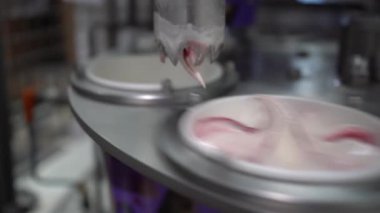 Modern Fabrikada Endüstriyel Dondurma Üretim Süreci, Otomatik Doldurma Makineleri Konveyör Hattı 'ndaki plastik konteynırlara Kremalı Tatlı Dökme, Gıda Üretimi