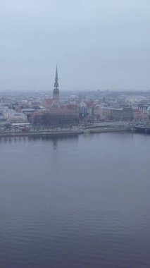 Letonya 'da Dondurucu bir sonbahar gününde, Riga Eski Kasabası' nın ön planda dalgalanan tarihi şehir merkezi, Daugava Nehri ve kentsel gökyüzü manzaralı insansız hava aracı görüntüsü