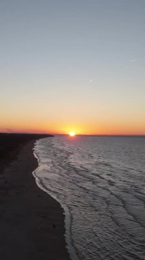 Lilaste Sahili üzerinde şaşırtıcı sonbahar günbatımı, Baltık Denizi Sahil Kıyısı 'nın Altın Saat Işığı, Dalgalar, Kum Kumulları ve Kuzey Avrupa' daki Serene Sahil Alanı