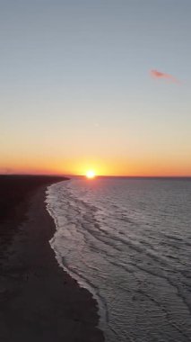 Lilaste Sahili üzerinde şaşırtıcı sonbahar günbatımı, Baltık Denizi Sahil Kıyısı 'nın Altın Saat Işığı, Dalgalar, Kum Kumulları ve Kuzey Avrupa' daki Serene Sahil Alanı