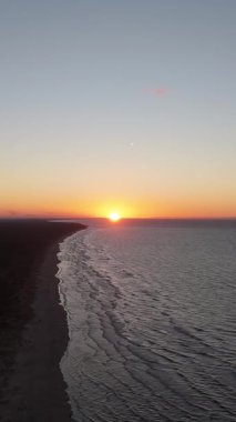 Lilaste Sahili üzerinde şaşırtıcı sonbahar günbatımı, Baltık Denizi Sahil Kıyısı 'nın Altın Saat Işığı, Dalgalar, Kum Kumulları ve Kuzey Avrupa' daki Serene Sahil Alanı