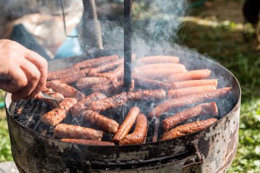 Bahçede ya da arka bahçede kömürlü barbekü ızgarası. Ön veya arka bahçedeki Black Kettle Grill 'in yan görüntüsü ve yeşil çimenler. Açık hava ızgarası için taşınabilir barbekü ızgarası