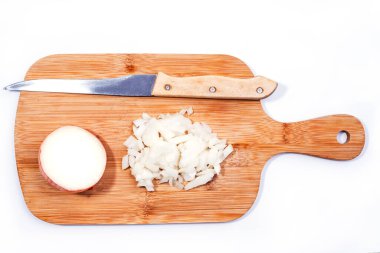 Beyaz arka planda izole edilmiş ahşap bir kesme tahtasının üzerinde doğranmış yarım soğan.