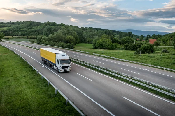 Gün batımında yarı karavanlı bir kamyon otoban boyunca gidiyor. Yoldan mal teslimatı. Hizmet ve Ulaştırma lojistiği