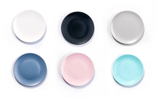 Set of six colorful empty plates isolated on white background top view. White, Black, Grey, Navy Blue, Pink, and Turquoise empty plates collection