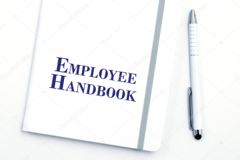 White Employee Handbook or manual with White pen on white table surface - personnel management policy, explains business goals, results, defines Leadership practices