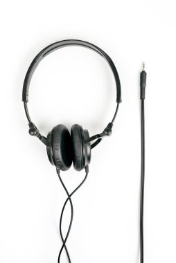 Beyaz arka planda siyah kulaklıklar ve fişe takmak için 3,5 mm 'lik kriko.