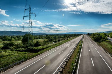 Boş, sessiz asfalt karayolu güzel gökyüzü ve bir sıra elektrik direkleriyle