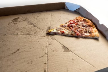 Karton bir kutuda son dilim pizza. Yemek teslimatı, fast food, pizza teslimatı.