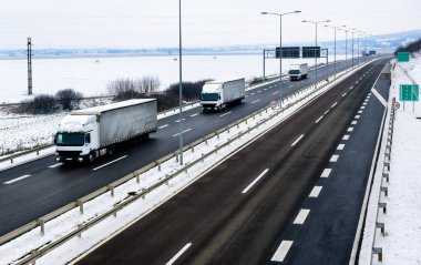 Karlı kış manzarasında Karlı bir Karayolunda Kamyon Konvoyu