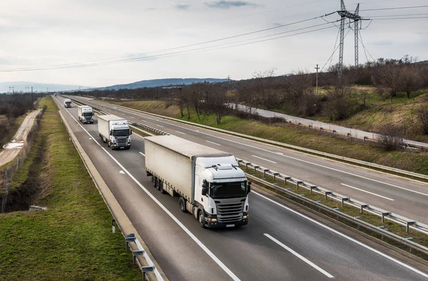 Transportation trucks passing by on a country highway road or motorway. Business Transportation and Trucking Industry.