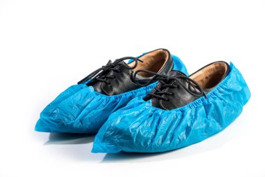 Beyaz arka planda izole edilmiş siyah deri ayakkabıların üzerindeki mavi plastik koruyucu ayakkabı kılıfları