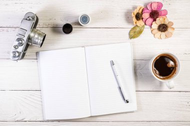 Tahta bir yüzey üzerinde bir fincan kahveyle, bir dizi fotoğraf makinası çerçevesinde dizayn edilmiş bir Not Defteri fotokopisi.