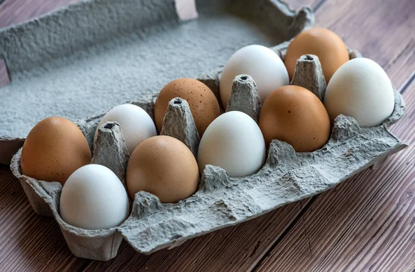 Kartong Med Tio Bruna Och Vita Ägg Ett Träbord Blandade — Stockfoto