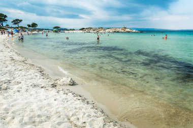 Karydi Plajı - Sithonia, Chalkidiki, Yunanistan - 8 Temmuz 2021: Ege kıyısı manzarası ve körfezdeki güzel samanlı plajı.