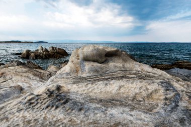 Kayalık plajın deniz manzarası ve güzel kaya oluşumları. Deniz dalgaları çarpar ve kayalara çarpar. Deniz manzarası, okyanus. Doğal yumuşak mavi arkaplan.