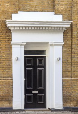 Siyah kapı ve Londra'nın sarı tuğla duvar