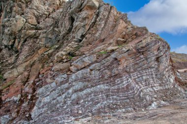 Zagros Dağları 'nın katmanlı kaya oluşumları, Kürdistan' da açık bir gökyüzünün altında belirgin kırmızı ve yeşil tortulu katmanlar içeriyor.