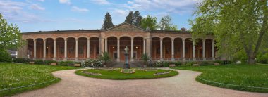 Trinkhalle binası, açık bir gezinti alanı oluşturan uzun, ritmik sütunlarıyla tanımlanır.