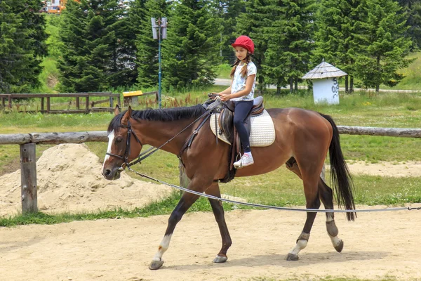 Menina jovem montando um cavalo — Fotografia de Stock