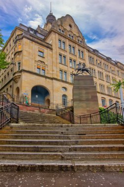 Basel 'deki Leonhard Spor Salonu klasik mimari, belirgin bir merdiven ve bir heykelin yer aldığı tarihi bir okul binasıdır.