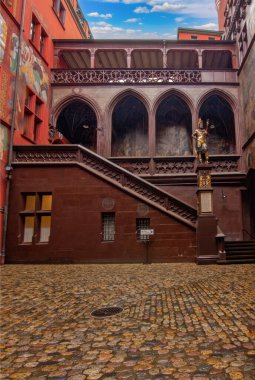 Basel Belediye Binası 'nın iç avlusunda zengin şekilde boyanmış duvarlar, tarihi kemerler, bir saat ve heykel ayrıntıları sergileniyor.,