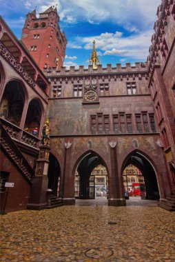 Basel Belediye Binası 'nın iç avlusunda zengin şekilde boyanmış duvarlar, tarihi kemerler, bir saat ve heykel ayrıntıları sergileniyor.,