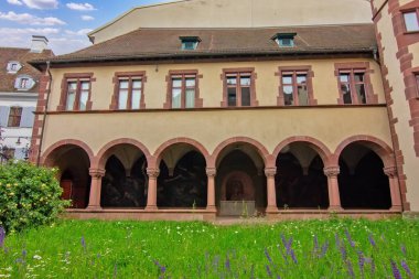 Basel 'de kemerleri, kulesi, yeşilliği ve sakin mimari ahengi olan huzurlu bir tarihi avlu..