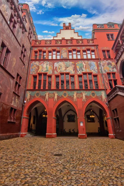 Basel Belediye Binası 'nın iç avlusunda zengin şekilde boyanmış duvarlar, tarihi kemerler, bir saat ve heykel ayrıntıları sergileniyor.,