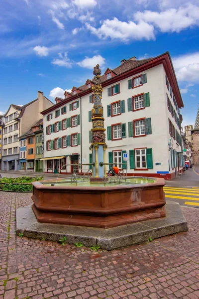 Basel 'de tarihi bir meydan. İçinde dekoratif bir çeşme, geleneksel binalar ve eski kasabadan geçen modern bir tramvay var..