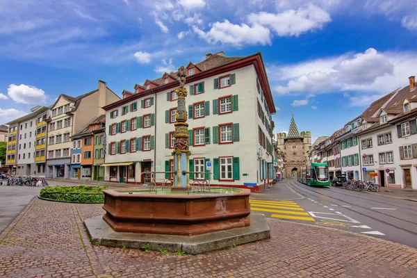 Basel 'de tarihi bir meydan. İçinde dekoratif bir çeşme, geleneksel binalar ve eski kasabadan geçen modern bir tramvay var..