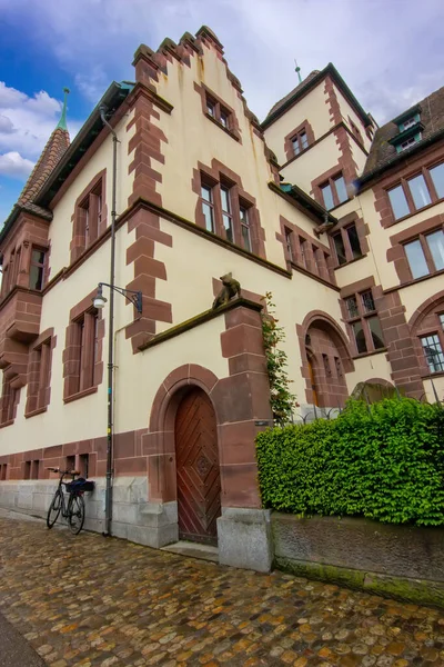 Taş cepheli tarihi bir Basel binası, avlu çeşmesi ve sakin eski kasaba atmosferi..