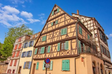 Colmar 'da dar bir sokakta çiçeklerle kaplı renkli tarihi kereste evleri..