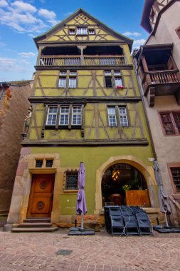 Colmar 'da dar bir sokakta çiçeklerle kaplı renkli tarihi kereste evleri..