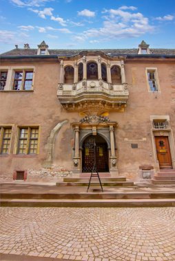 Colmar 'da oymalı balkon ve kemerli girişi olan eski tarihi muhafız evi cephesi..