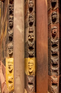 Orta çağ yüzleri ve taş süslemeleri gösteren Gotik kilise sütununa yakından bakın..