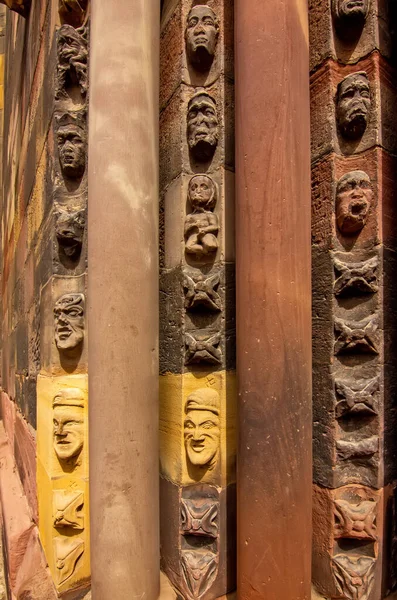 Orta çağ yüzleri ve taş süslemeleri gösteren Gotik kilise sütununa yakından bakın..