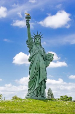 Fransa 'nın Colmar kentindeki mavi gökyüzünün altındaki yeşil parkta duran ünlü Bartholdi anıtı kopyası.