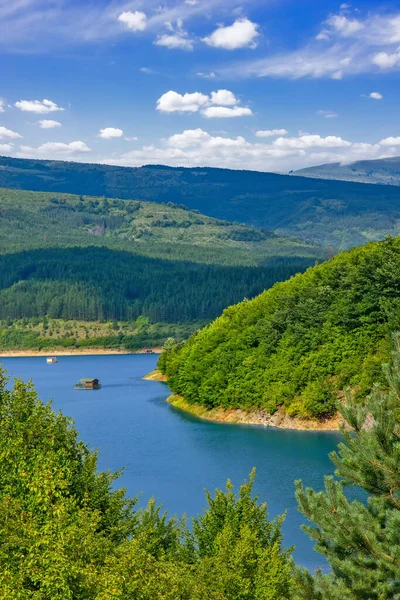 Sırbistan 'ın güneydoğusundaki Pirot yakınlarındaki orman tepeleri ve dağlarla çevrili Zavoj Gölü' nün panoramik manzarası mavi gökyüzünün altında