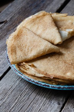 Ahşap bir arka planda tabakta krep. Çıtır çıtır krep. Maslenitsa. Kahvaltı ve karnaval için gözleme. Gıda arkaplanı.