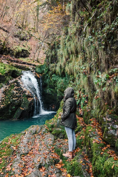 滝のそばのジャケットの女の子 秋または冬のヨーロッパで時間 寒い気候と自然の美しさを屋外で楽しむ女性 自由生活 — ストック写真